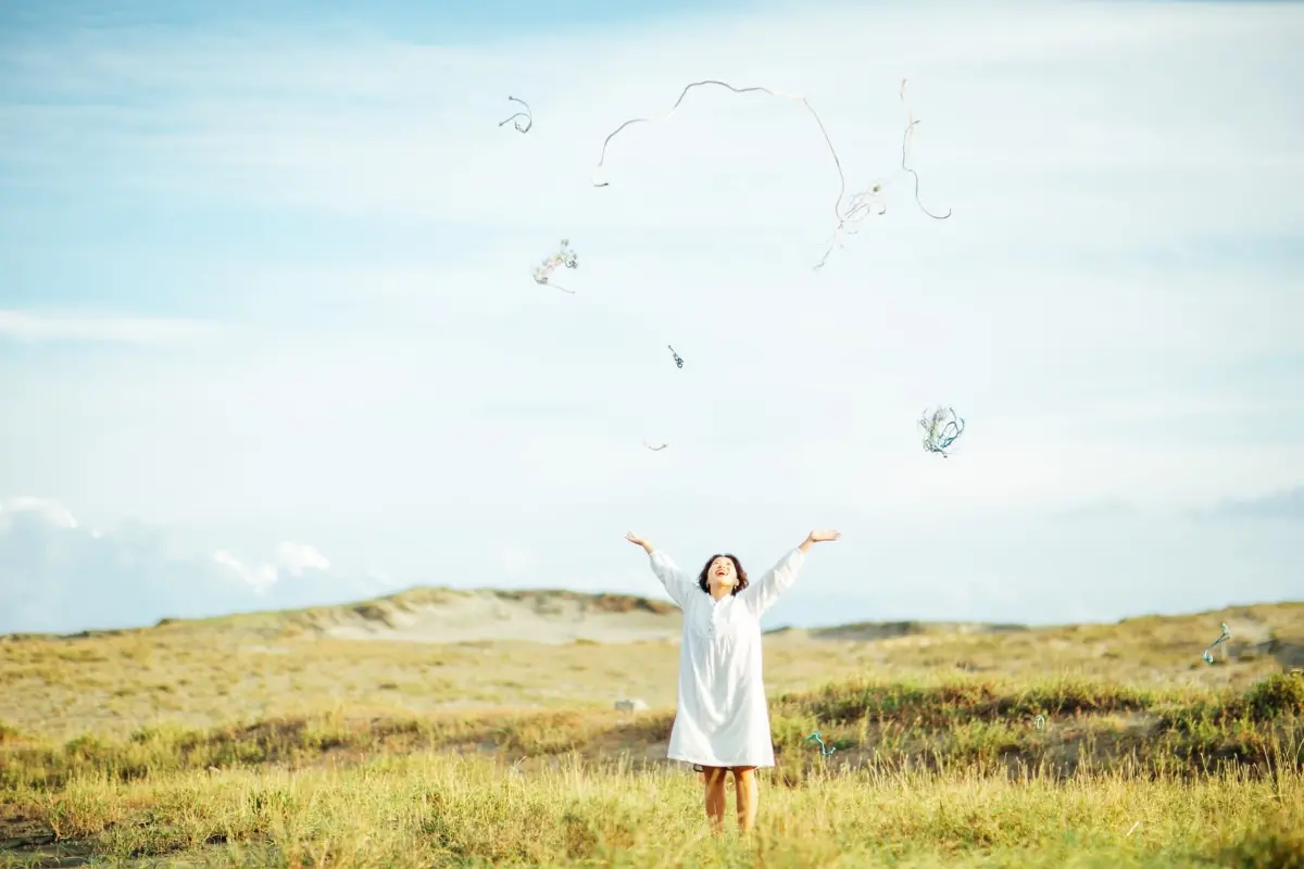 女性が野原で喜んでいる画像